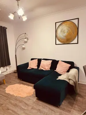 a living room with a black couch and a fan at Entire Immaculate 3 Bedrooms House in Blackburn Weekend Away in Blackburn