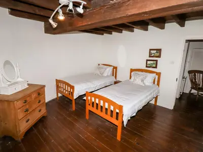 a bedroom with two beds and a dresser and a tv at Windmill On The Farm in Ormskirk