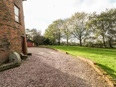a dirt road next to a brick building at Windmill On The Farm in Ormskirk