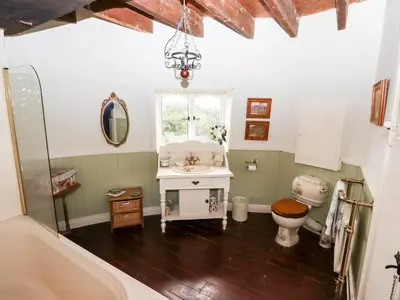 a bathroom with a sink and a toilet and a window at Windmill On The Farm in Ormskirk