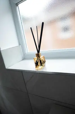 a vase with sticks in it sitting on a window sill at Woodland House - in Walton le Dale