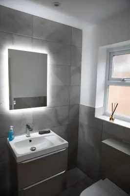 a bathroom with a white sink and a mirror at Woodland House - in Walton le Dale
