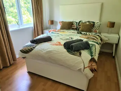 a bedroom with a large bed with a white comforter at Woodland House - in Walton le Dale