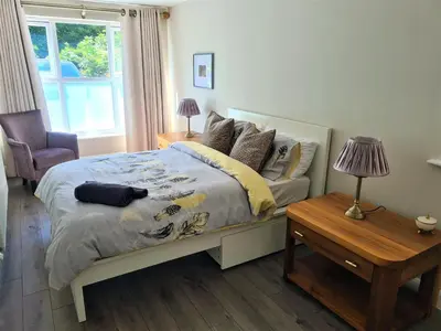 a bedroom with a bed and a table and a window at Woodland House - in Walton le Dale