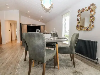 a dining room with a table with chairs and a mirror at Ruperts Retreat in Preston
