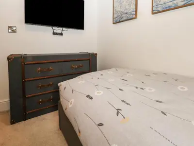a bedroom with a bed and a dresser and a television at Ruperts Retreat in Preston