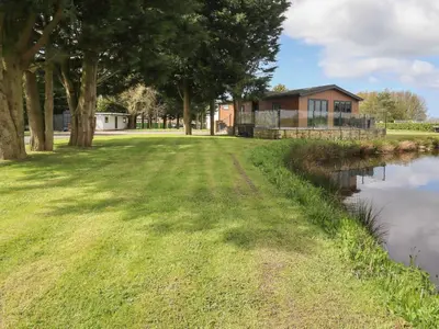 a house on the side of a river with trees at Ruperts Retreat in Preston