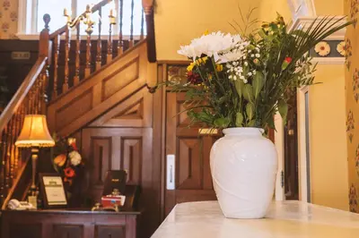 a white vase filled with flowers sitting on a table at Trivelles Park Hotel in Preston