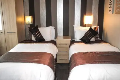 a hotel room with two beds and a night stand at Trivelles Park Hotel in Preston