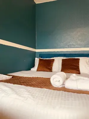 a bedroom with a large bed with towels on it at Jewel Of The Sea Hotel in Blackpool