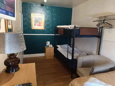 a room with two bunk beds and a desk at Jewel Of The Sea Hotel in Blackpool