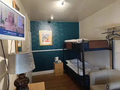 a room with two bunk beds and a flat screen tv at Jewel Of The Sea Hotel in Blackpool
