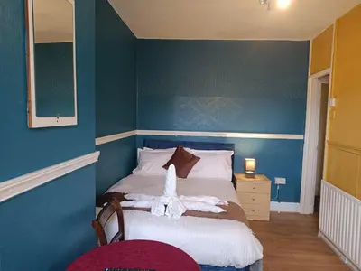 a bedroom with a bed with a blue wall at Jewel Of The Sea Hotel in Blackpool