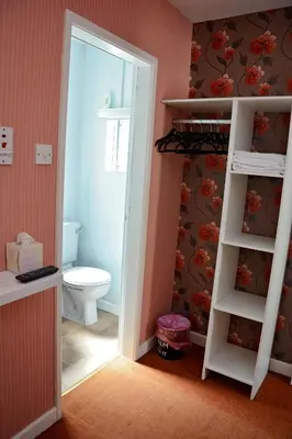 a bathroom with a toilet and a door leading into a room at Tobermory Hotel in Blackpool
