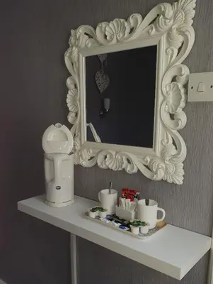 a mirror on top of a shelf in a bathroom at Tobermory Hotel in Blackpool