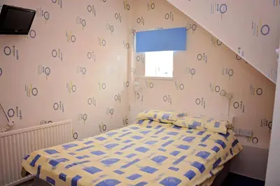 a bedroom with a bed in a room with numbers on the wall at Tobermory Hotel in Blackpool