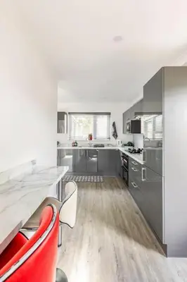 a kitchen with a table and some red chairs at Lookout 5-Bed House in Darwen Blackburn BB1 Free Parking Roadside in Rishton