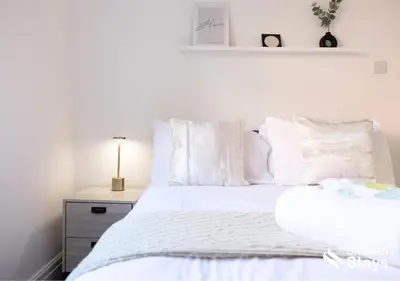 a bedroom with a bed with white sheets and pillows at One Bedroom Apartment At Smooth Stays Short Lets & Serviced Accommodation Preston With Parking Near Train Station in Preston