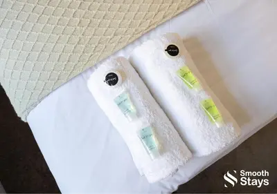 two white towels sitting on top of a bed at One Bedroom Apartment At Smooth Stays Short Lets & Serviced Accommodation Preston With Parking Near Train Station in Preston