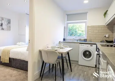 a kitchen and bedroom with a bed and a table at One Bedroom Apartment At Smooth Stays Short Lets & Serviced Accommodation Preston With Parking Near Train Station in Preston