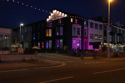 a building with purple lights on a street at night at Ferny House in Blackpool