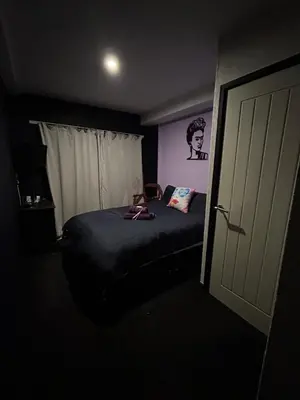 a bedroom with a bed in a dark room at Ferny House in Blackpool