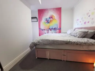 a bedroom with a bed with a painting of two birds at 'The Love Nest' Apartment Liverpool, Netflix in Liverpool