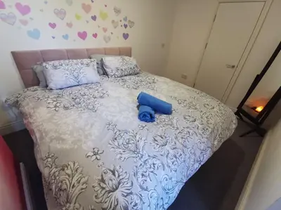 a blue teddy bear sitting on top of a bed at 'The Love Nest' Apartment Liverpool, Netflix in Liverpool