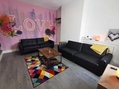 a living room with a black couch and a table at 'The Love Nest' Apartment Liverpool, Netflix in Liverpool