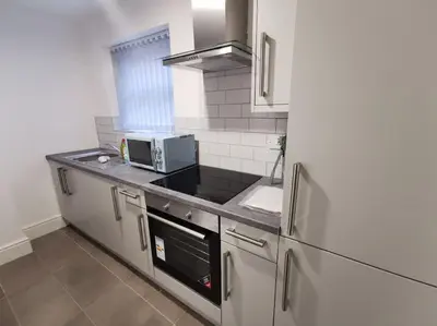 a kitchen with a sink and a refrigerator at 'The Love Nest' Apartment Liverpool, Netflix in Liverpool