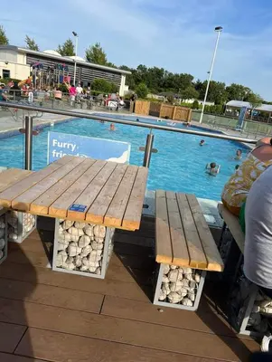 a picnic table in front of a swimming pool at Rydal Retreat Lakeland Holiday Park in Flookburgh
