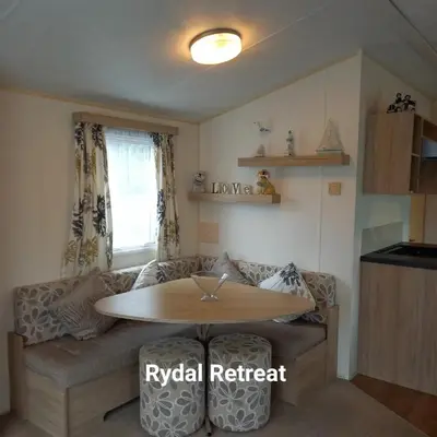 a living room with a table and a couch at Rydal Retreat Lakeland Holiday Park in Flookburgh