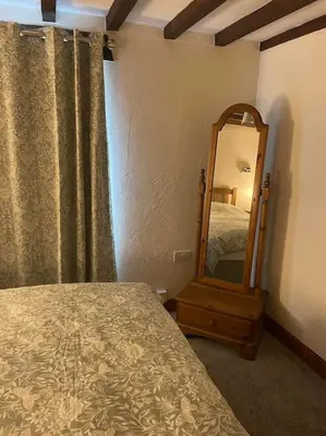 a bedroom with a mirror next to a bed at Braffin @ Fellside Farm, Pennington, Ulverston in Pennington