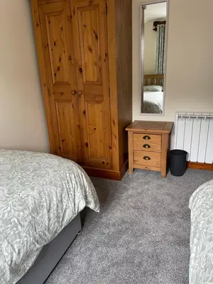 a bedroom with a bed and a dresser and a mirror at Braffin @ Fellside Farm, Pennington, Ulverston in Pennington