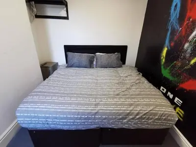 a bedroom with a bed with a poster on the wall at The Bob Marley 'One Love' Apartment, Relaxed Vibes in Liverpool
