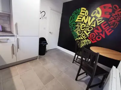a kitchen with a table and a wall with graffiti at The Bob Marley 'One Love' Apartment, Relaxed Vibes in Liverpool