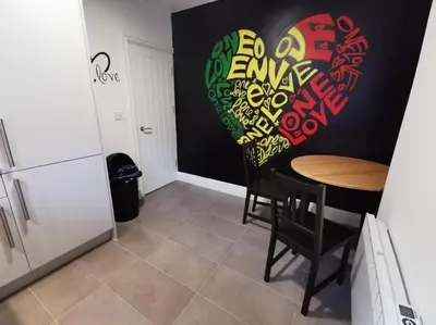 a kitchen with a table with a heart painted on the wall at The Bob Marley 'One Love' Apartment, Relaxed Vibes in Liverpool