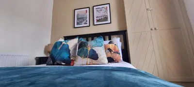 a bed with a blue blanket and pillows on it at Toffees Townhouse a 2 Bed House in Liverpool 1 Mins walk to Goodison Park in Liverpool