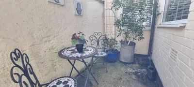 a table with a potted plant on it next to a building at Toffees Townhouse a 2 Bed House in Liverpool 1 Mins walk to Goodison Park in Liverpool