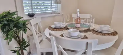 a white table with white chairs and a bottle of wine at Toffees Townhouse a 2 Bed House in Liverpool 1 Mins walk to Goodison Park in Liverpool