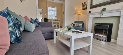 a living room with a couch and a fireplace at Toffees Townhouse a 2 Bed House in Liverpool 1 Mins walk to Goodison Park in Liverpool