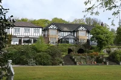 a large house with a statue in front of it at Higher Trapp Hotel in Burnley
