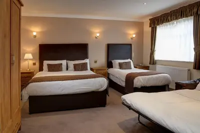 a hotel room with two beds and a window at Higher Trapp Hotel in Burnley