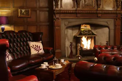 a living room with leather furniture and a fireplace at Higher Trapp Hotel in Burnley