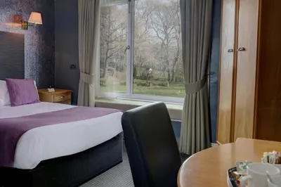 a hotel room with a bed and a window at Higher Trapp Hotel in Burnley
