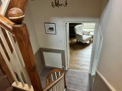 a hallway with a staircase and a chair in a house at 5 Castle Hill in Lancaster