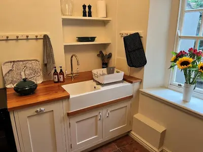 a kitchen with a sink and a vase of flowers at 5 Castle Hill in Lancaster
