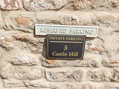 a sign for reserved parking on a stone wall at 5 Castle Hill in Lancaster