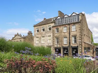 an old stone house with a garden in front of it at 5 Castle Hill in Lancaster
