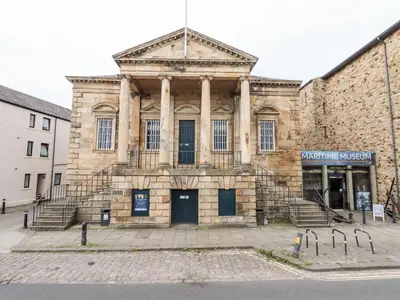 an old stone building with stairs in front of it at 5 Castle Hill in Lancaster